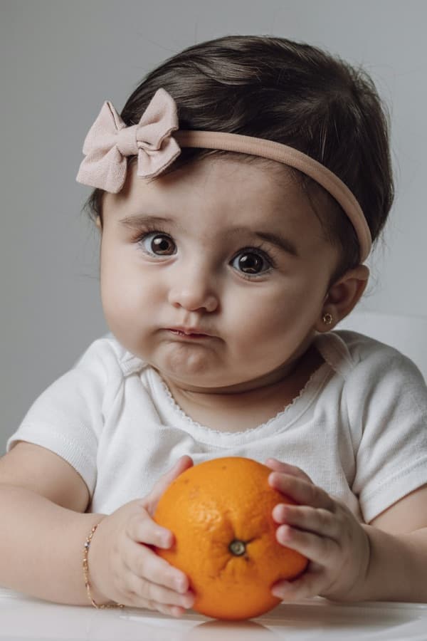 A baby discovering an orange